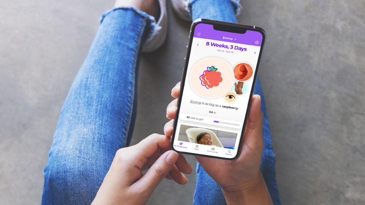 What to Expect Pregnancy and Baby App, woman in jeans looking at the app on her phone