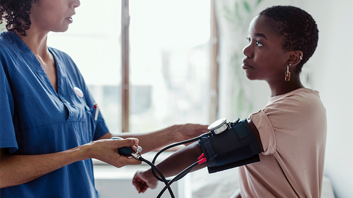 eclampsia during pregnancy, woman getting her blood pressure checked at the doctor's