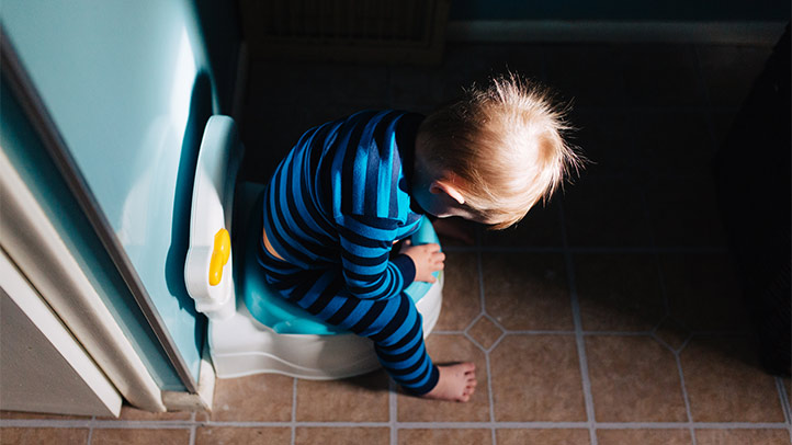 best potty training methods, toddler boy looking at training toilet