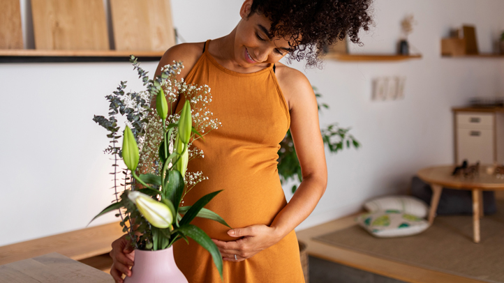 woman holding her bump in her second trimester of pregnancy, second trimester of pregnancy guide