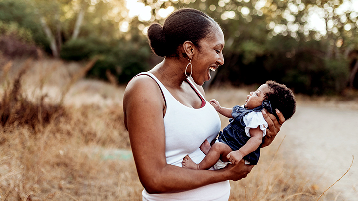 the 4th trimester, new mom holding newborn baby in a park